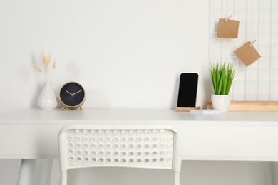 Photo of Comfortable workplace with white desk near wall at home