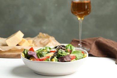 Photo of Delicious fresh carrot salad served on white wooden table. Space for text