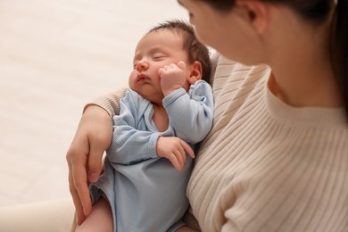 Photo of Mother with her sleeping newborn baby on light background, closeup