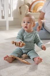 Photo of Cute baby girl playing with wooden toys and mother on floor at home