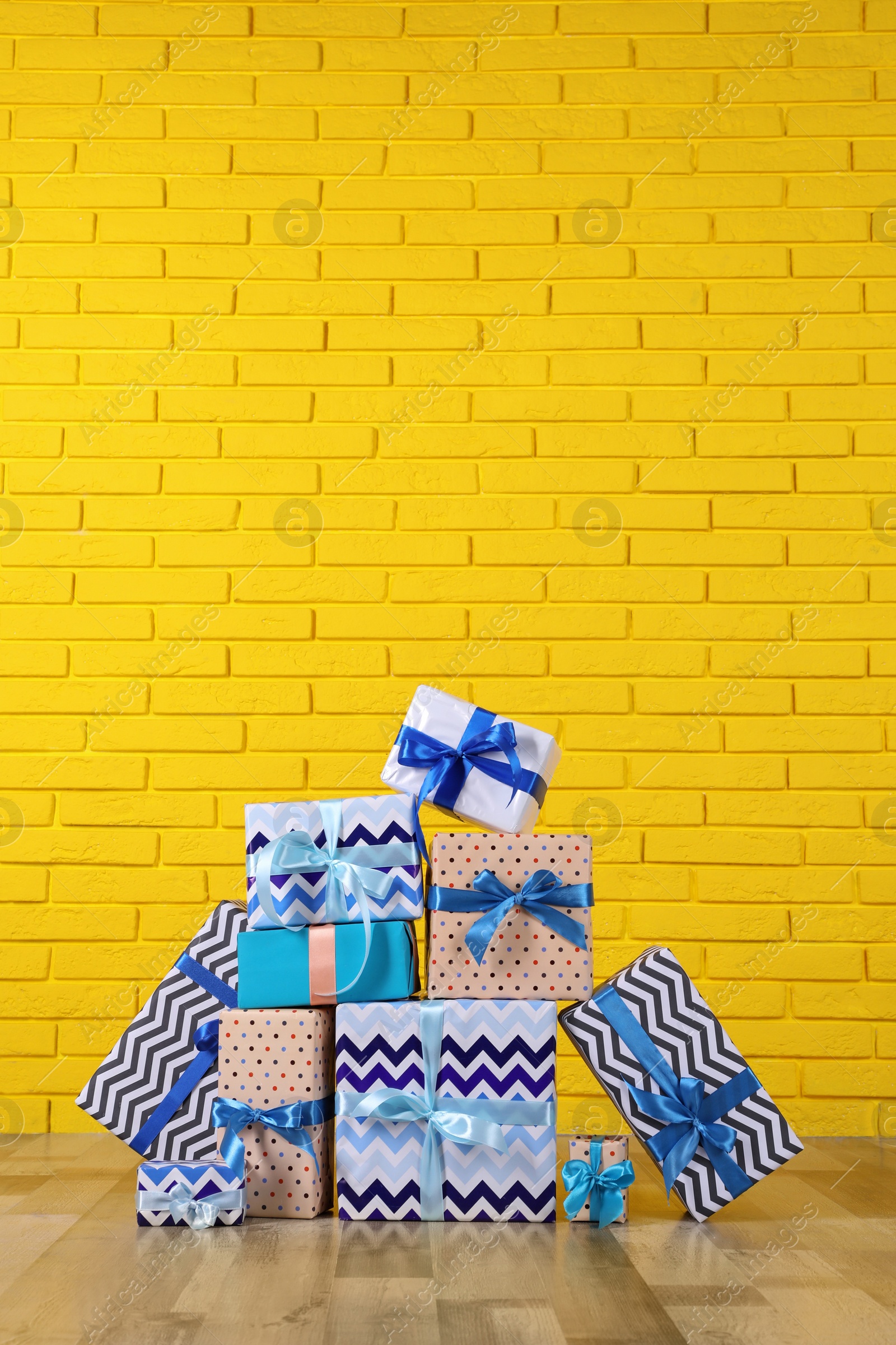 Photo of Many gift boxes near yellow brick wall