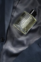 Luxury men's perfume in bottle on grey jacket, top view. Space for text