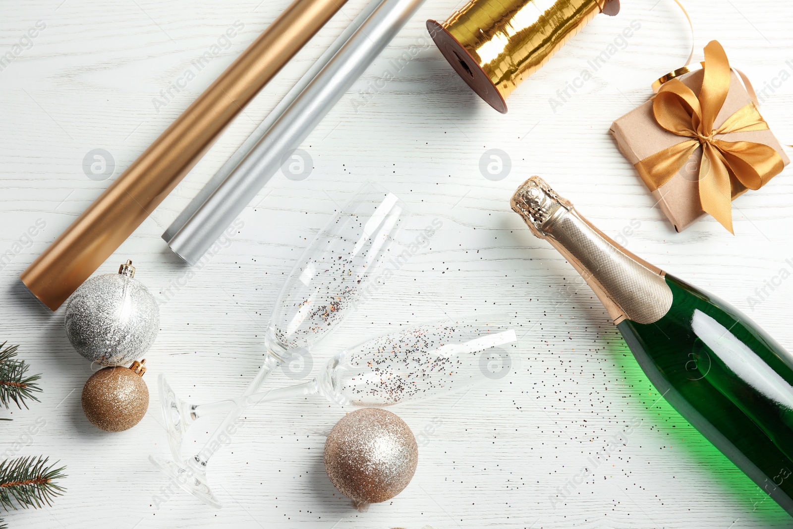 Photo of Christmas composition with bottle of champagne and glasses on wooden background, top view