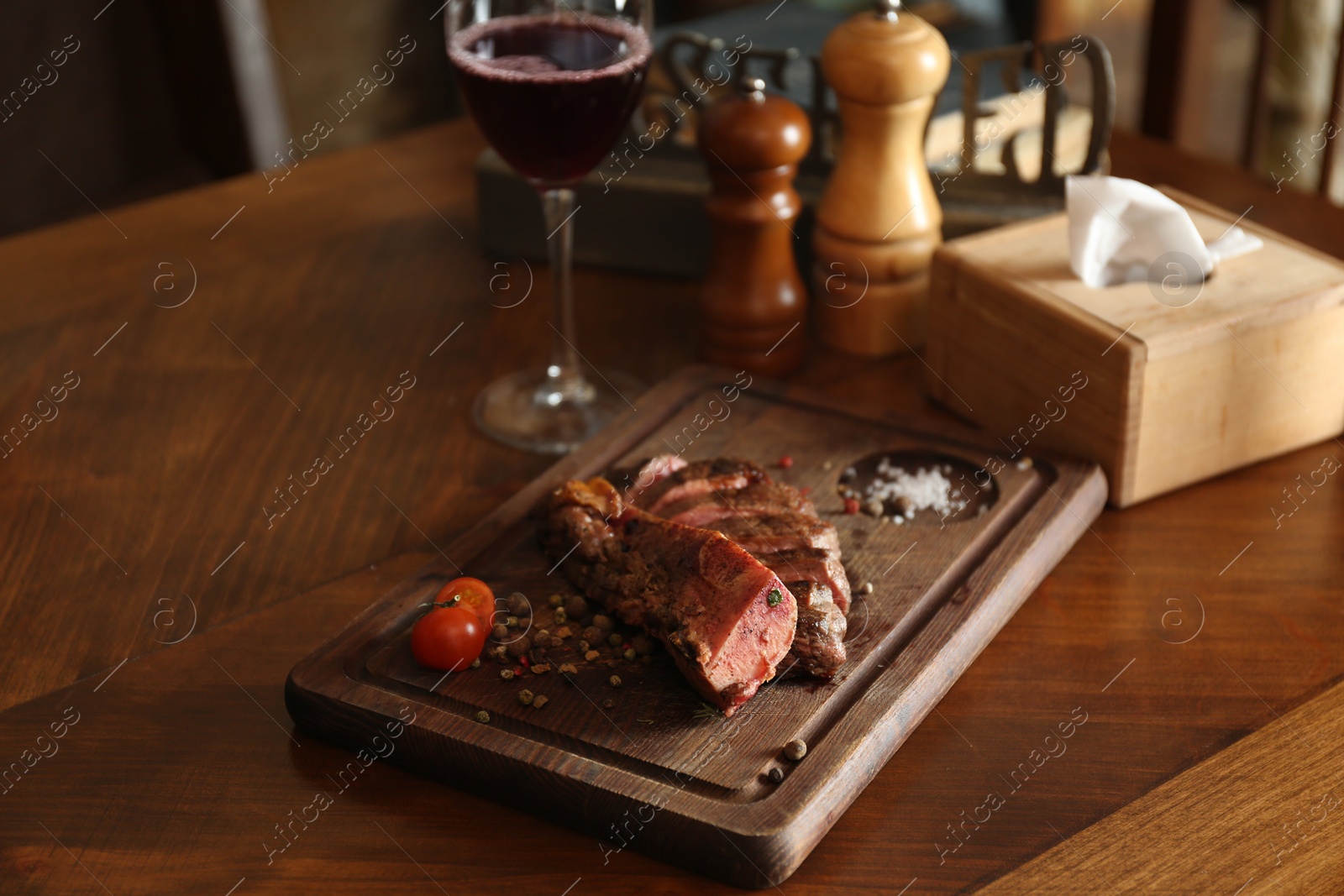 Photo of Tasty roasted meat served on wooden table in restaurant. Cooking food