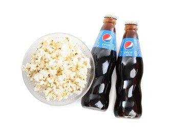 MYKOLAIV, UKRAINE - FEBRUARY 15, 2021: Glass bottles of Pepsi and snack on white background, top view