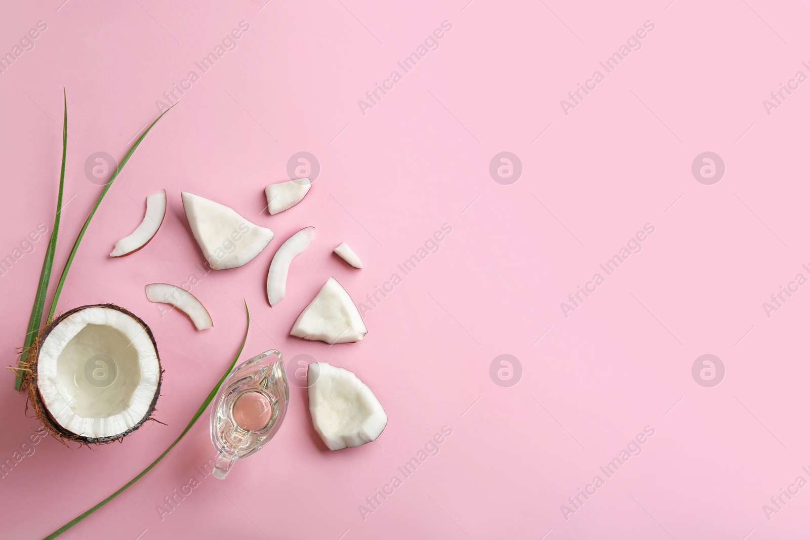 Photo of Flat lay composition with ripe coconut, natural organic oil and space for text on pink background