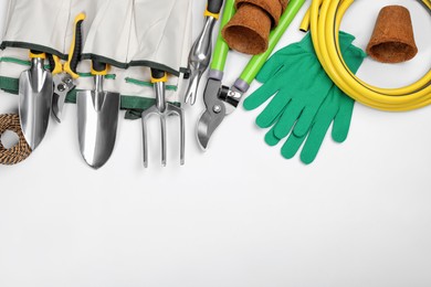 Flat lay composition with gardening tools on white background, space for text