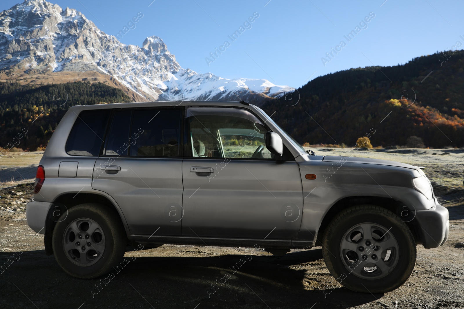 Photo of Big car parked in beautiful high mountains on sunny day