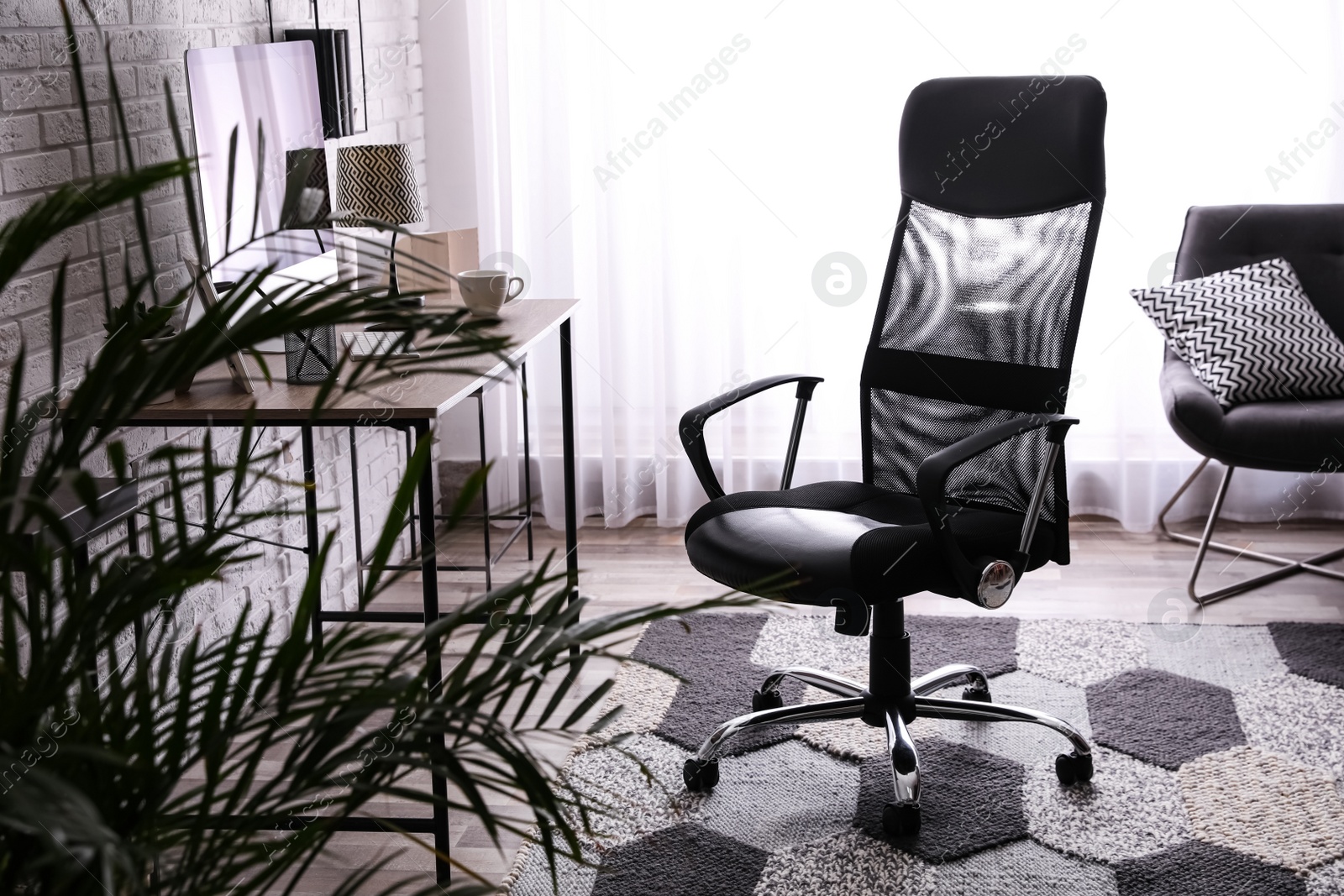 Photo of Comfortable chair near desk in modern office interior