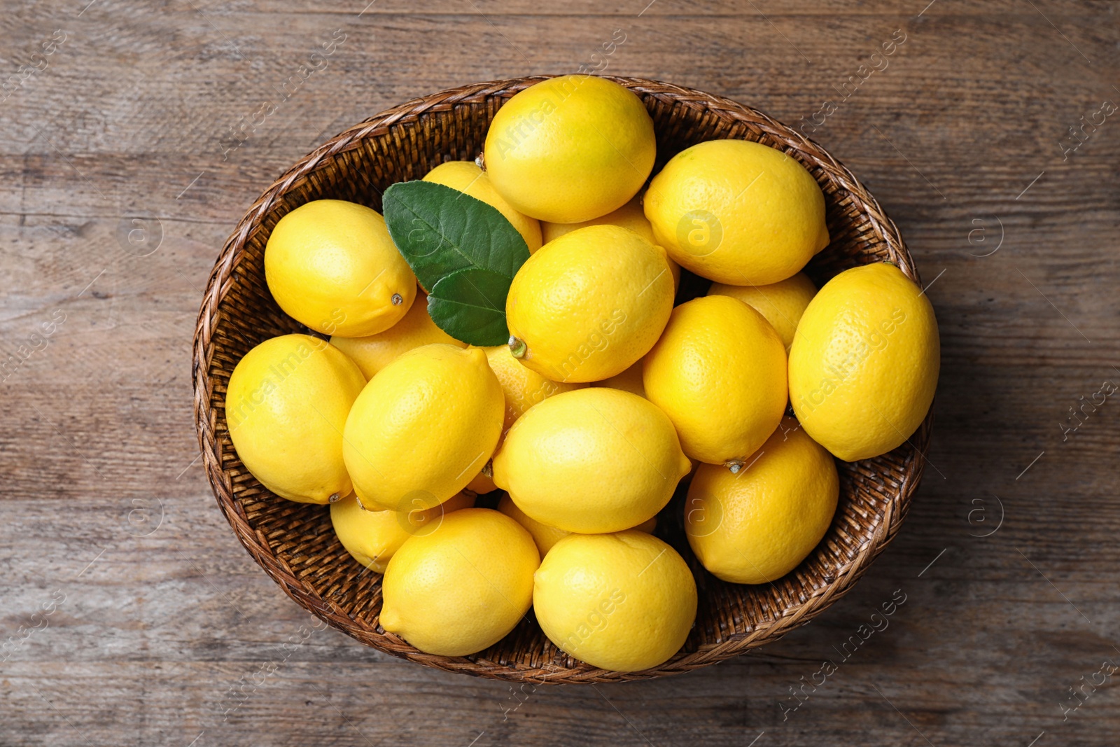 Photo of Fresh ripe lemons on wooden table, top view