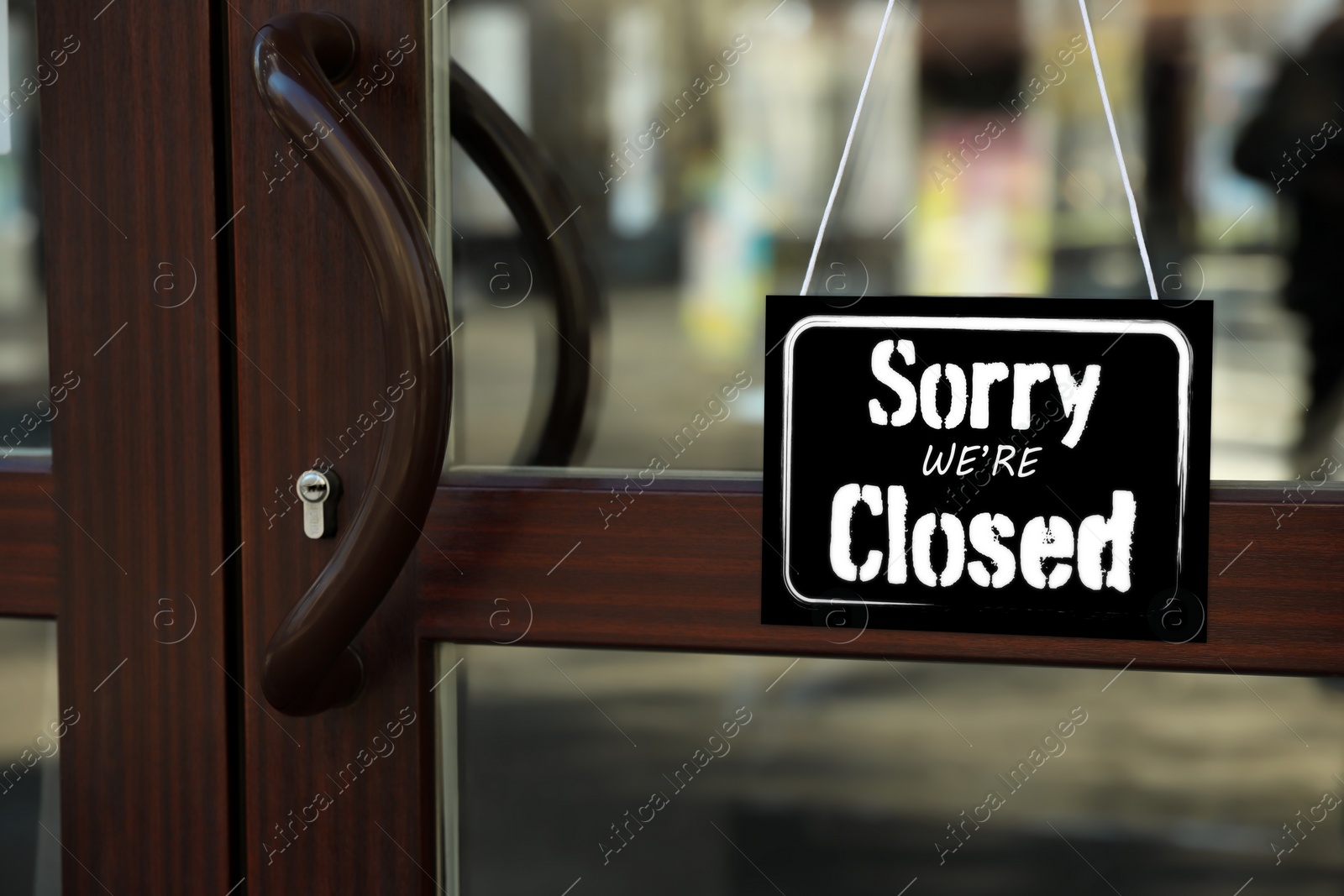 Image of Sorry we are closed sign hanging on glass door