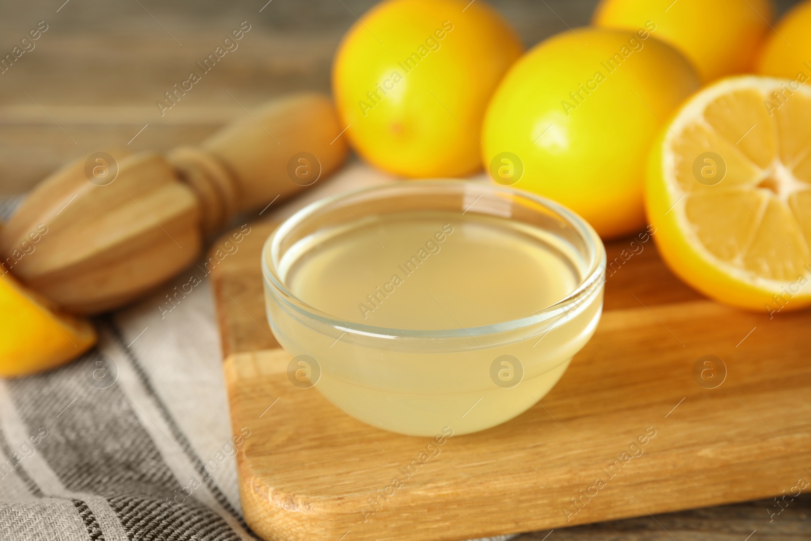 Photo of Freshly squeezed juice, lemons and reamer on table