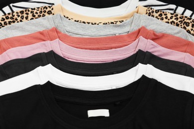 Photo of Many stacked clothes as background, top view