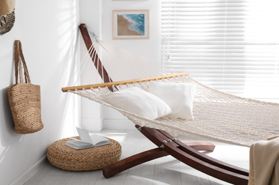 Photo of Comfortable hammock with pillows in stylish room. Interior design