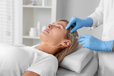 Trichologist giving injection to patient in clinic, closeup