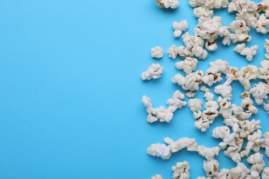 Tasty popcorn on light blue background, flat lay. Space for text