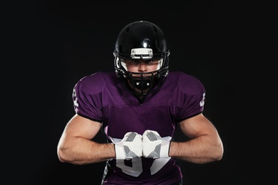 American football player wearing uniform on dark background