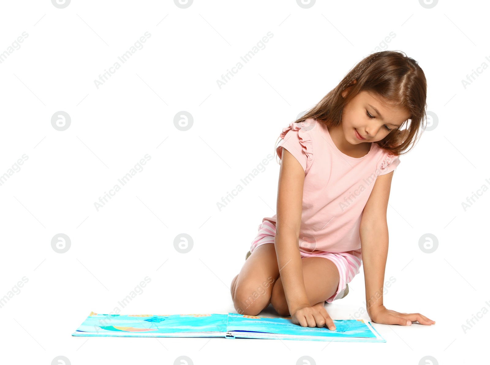 Photo of Cute little girl reading book on white background