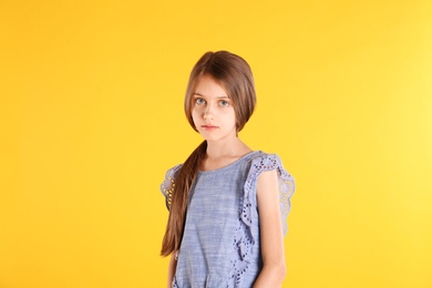 Photo of Portrait of cute little girl on yellow background