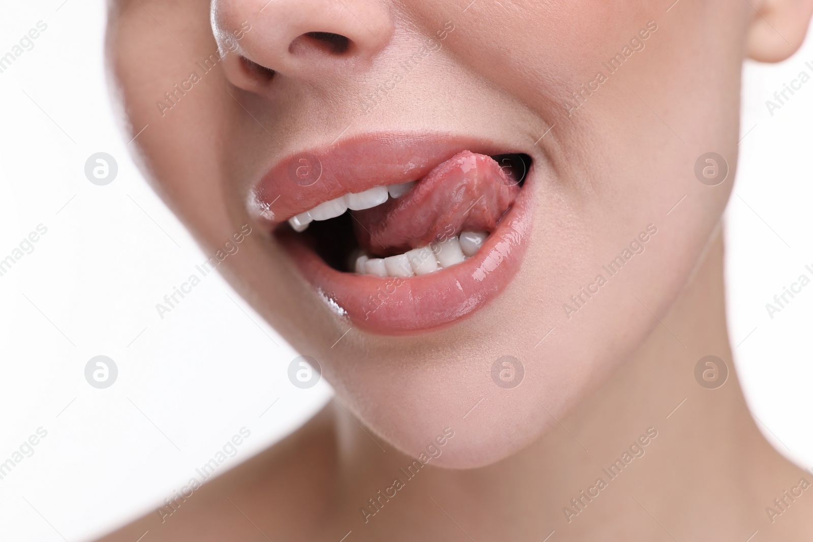 Photo of Woman with beautiful lips licking her teeth on white background, closeup