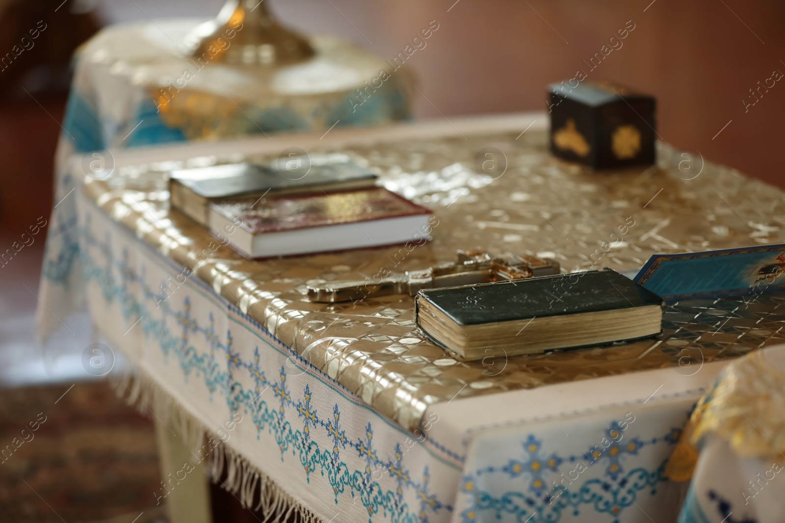 Photo of Ecclesiastical books and cross on communion table in church. Baptism ceremony