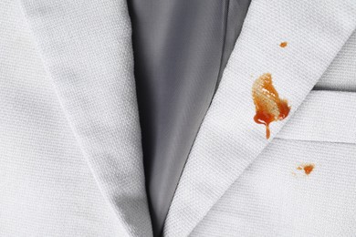 Photo of Dirty jacket with stains of sauce, top view