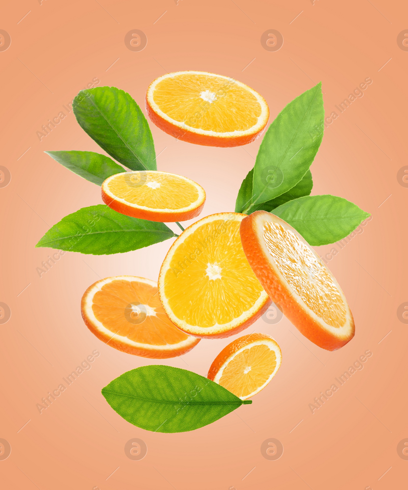 Image of Juicy orange slices and green leaves flying on peach background