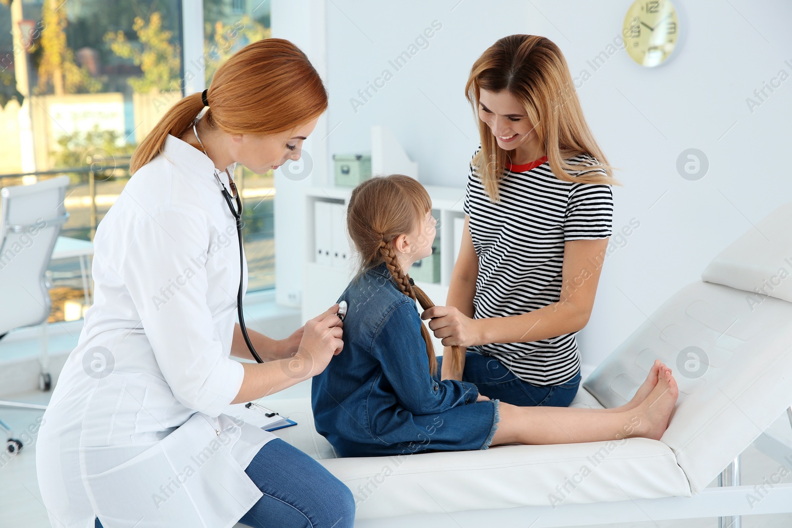 Photo of Children's doctor examining patient with stethoscope in hospital