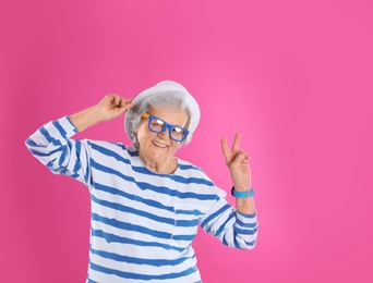 Photo of Portrait of cool grandmother on color background, space for text
