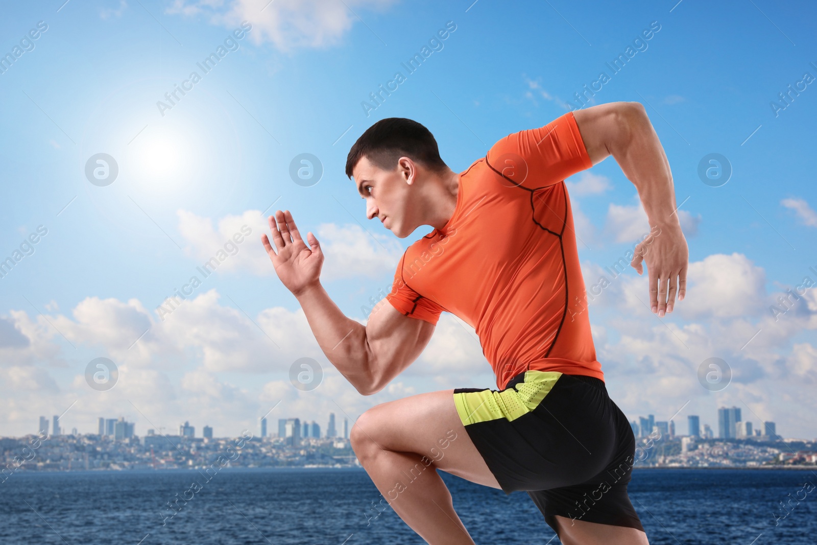 Image of Athletic young man running near sea on sunny day