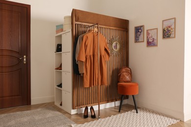 Photo of Modern hallway interior with stylish furniture and clothes rack