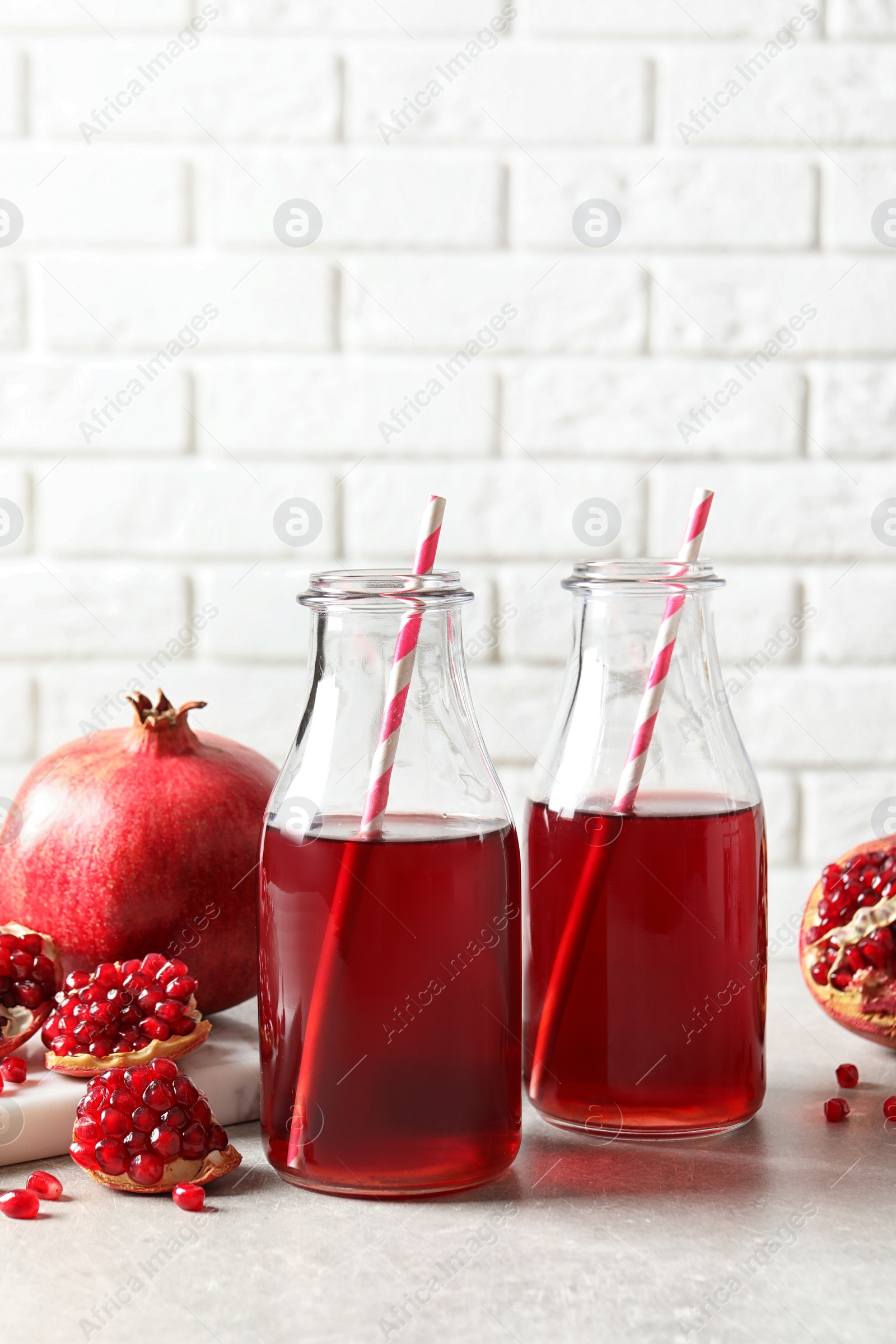 Photo of Composition with bottles of fresh pomegranate juice on table