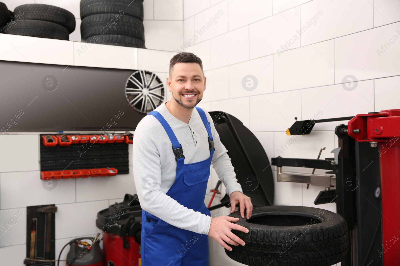 Photo of Mechanic working with tire fitting machine at car service