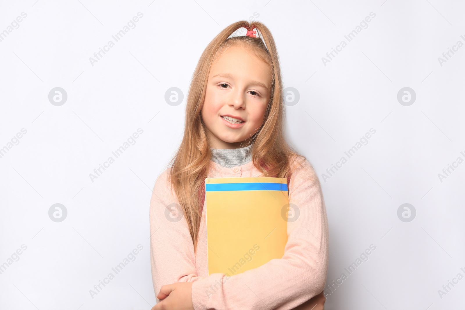 Photo of Happy little girl with magazine on white background