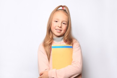 Happy little girl with magazine on white background