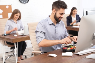 Photo of Office employees having lunch at workplace. Food delivery