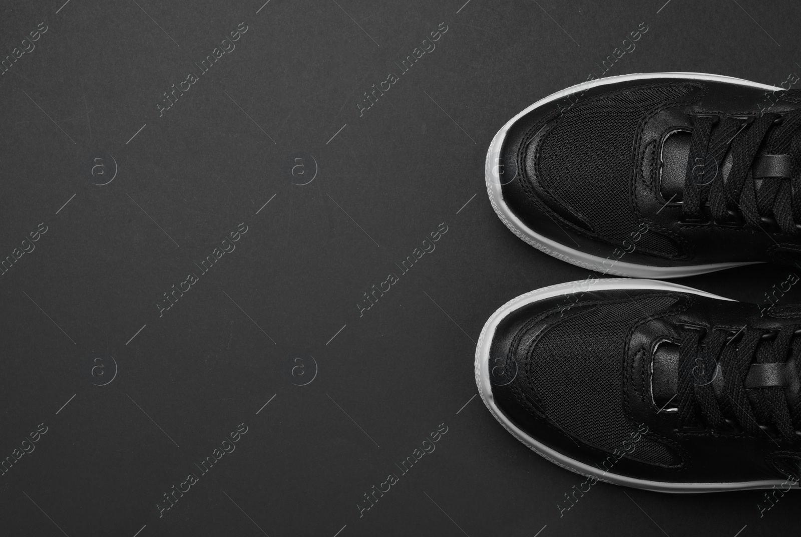 Photo of Pair of stylish shoes on black background, top view. Space for text