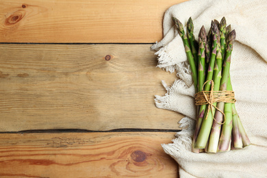 Fresh raw asparagus on wooden table, flat lay. Space for text