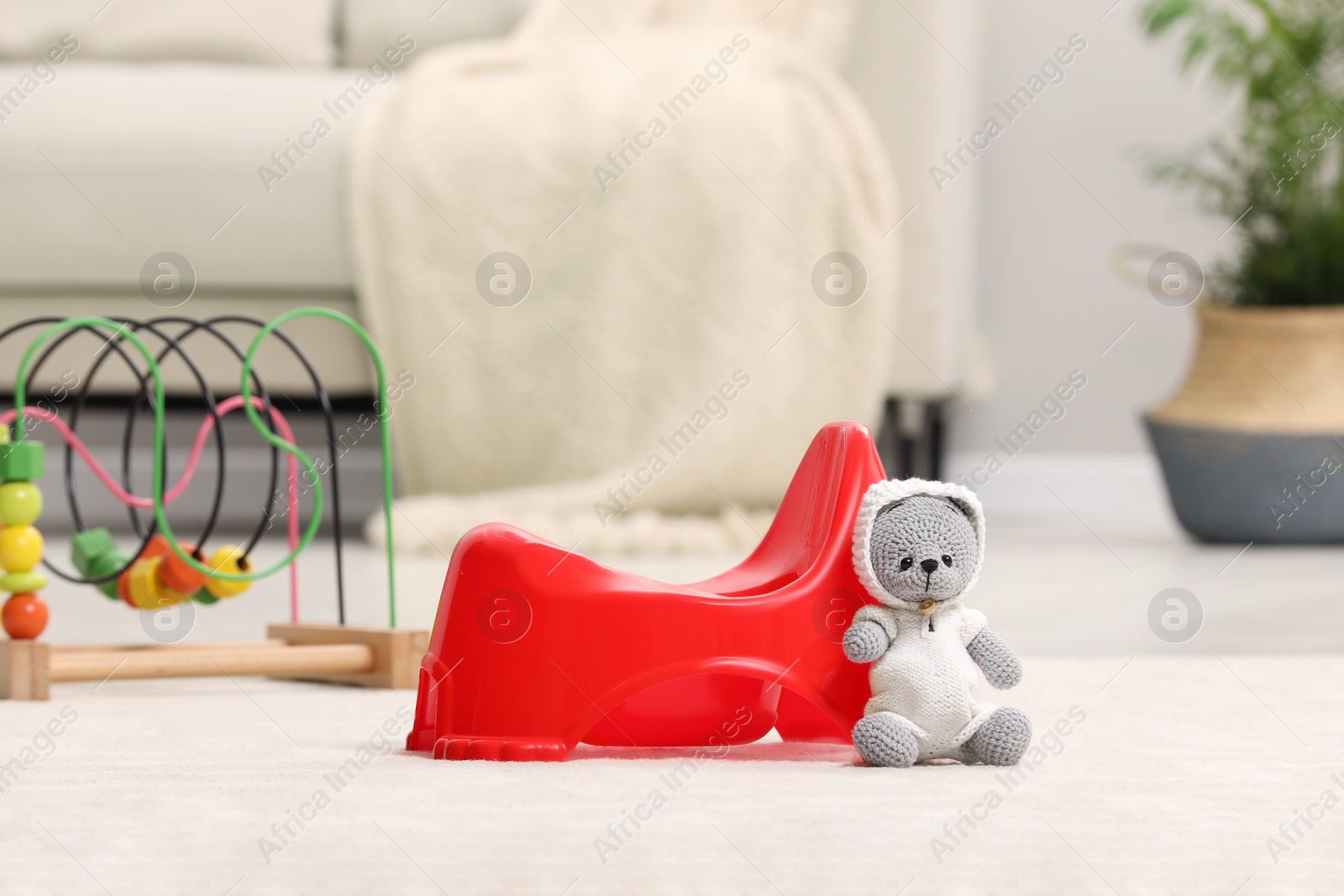 Photo of Red baby potty and toys in room. Toilet training