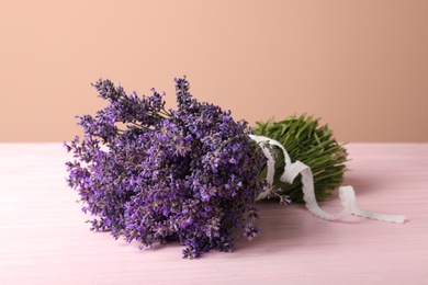 Photo of Beautiful lavender bouquet on pink wooden table