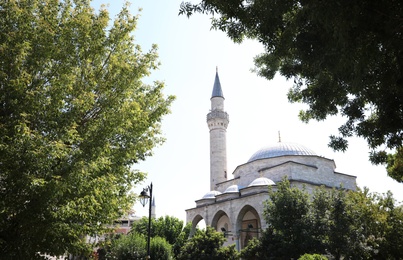 ISTANBUL, TURKEY - AUGUST 10, 2019: Beautiful Sultan Ahmed Mosque (Blue Mosque) through trees on sunny day