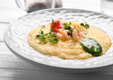 Plate with tasty shrimps and grits on table