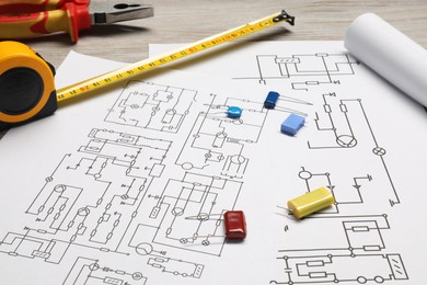 Photo of Wiring diagrams and tools on white table, closeup