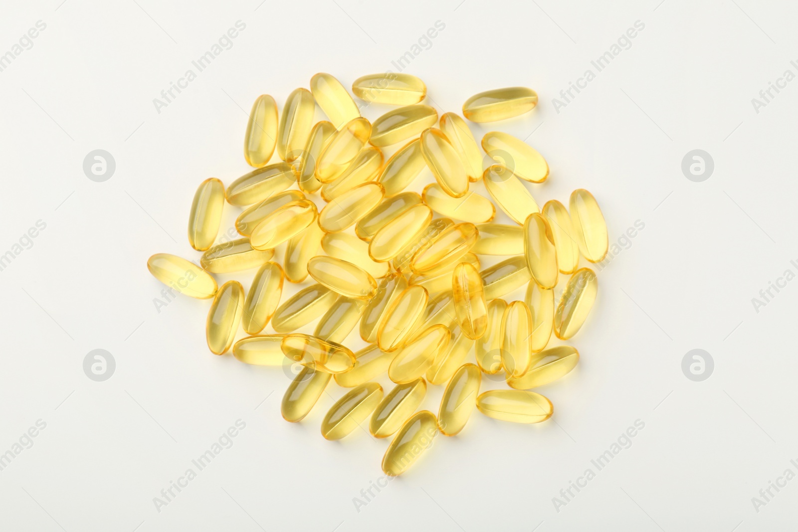 Photo of Yellow vitamin capsules on white background, top view