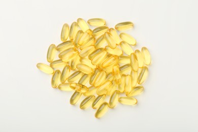 Photo of Yellow vitamin capsules on white background, top view