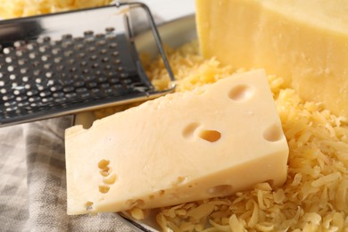 Grated and whole pieces of cheese on cloth, closeup