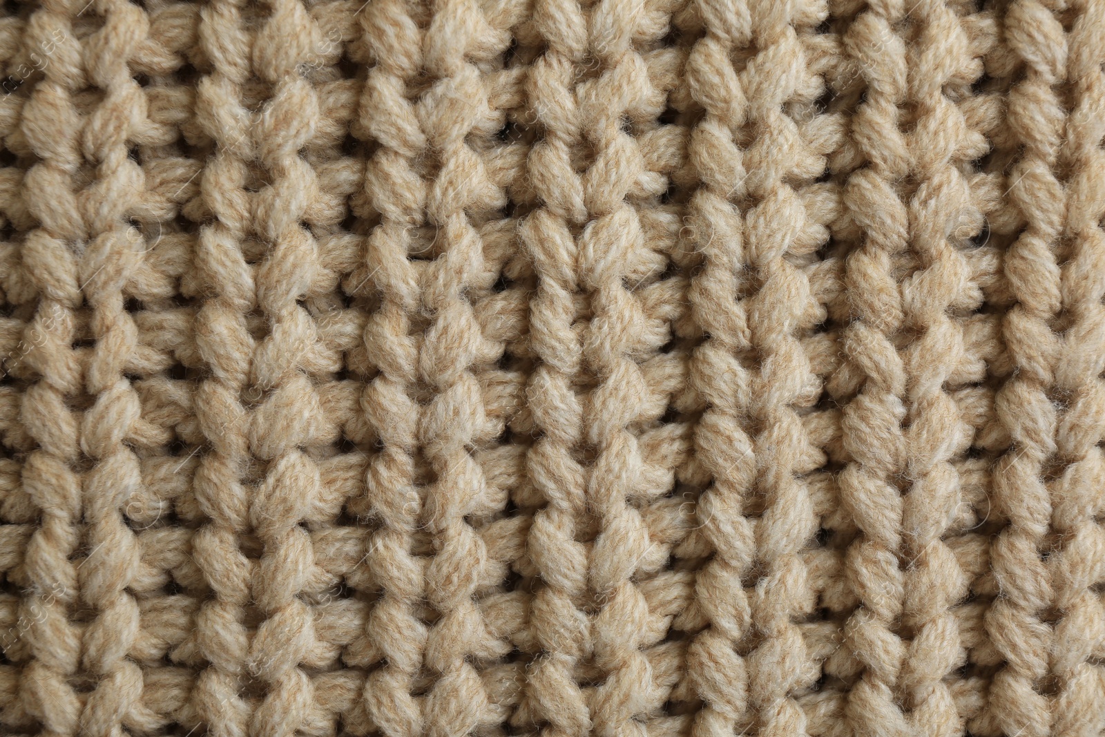 Photo of Beautiful beige knitted fabric as background, top view