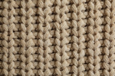 Photo of Beautiful beige knitted fabric as background, top view