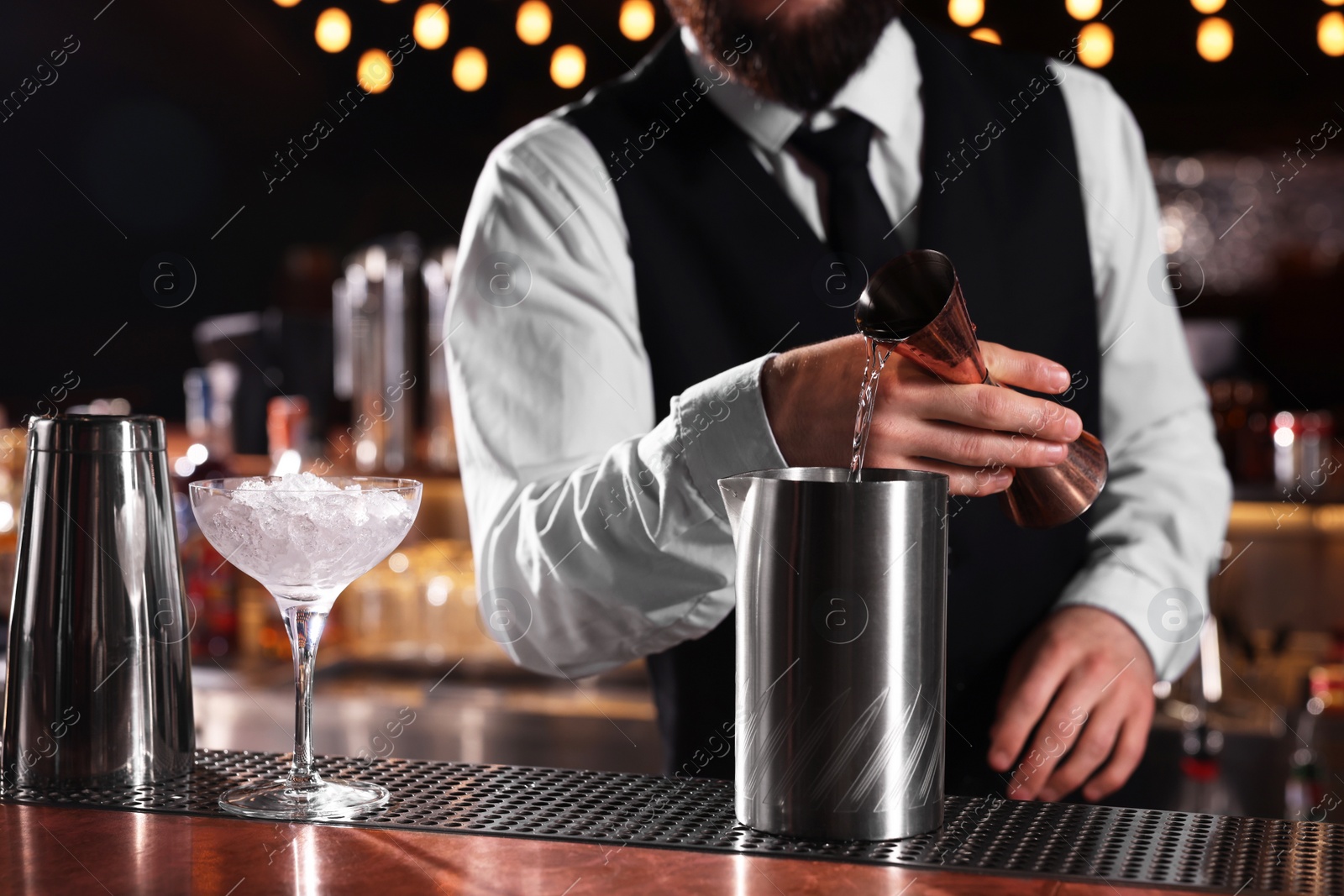 Photo of Bartender preparing fresh alcoholic cocktail at bar counter, closeup