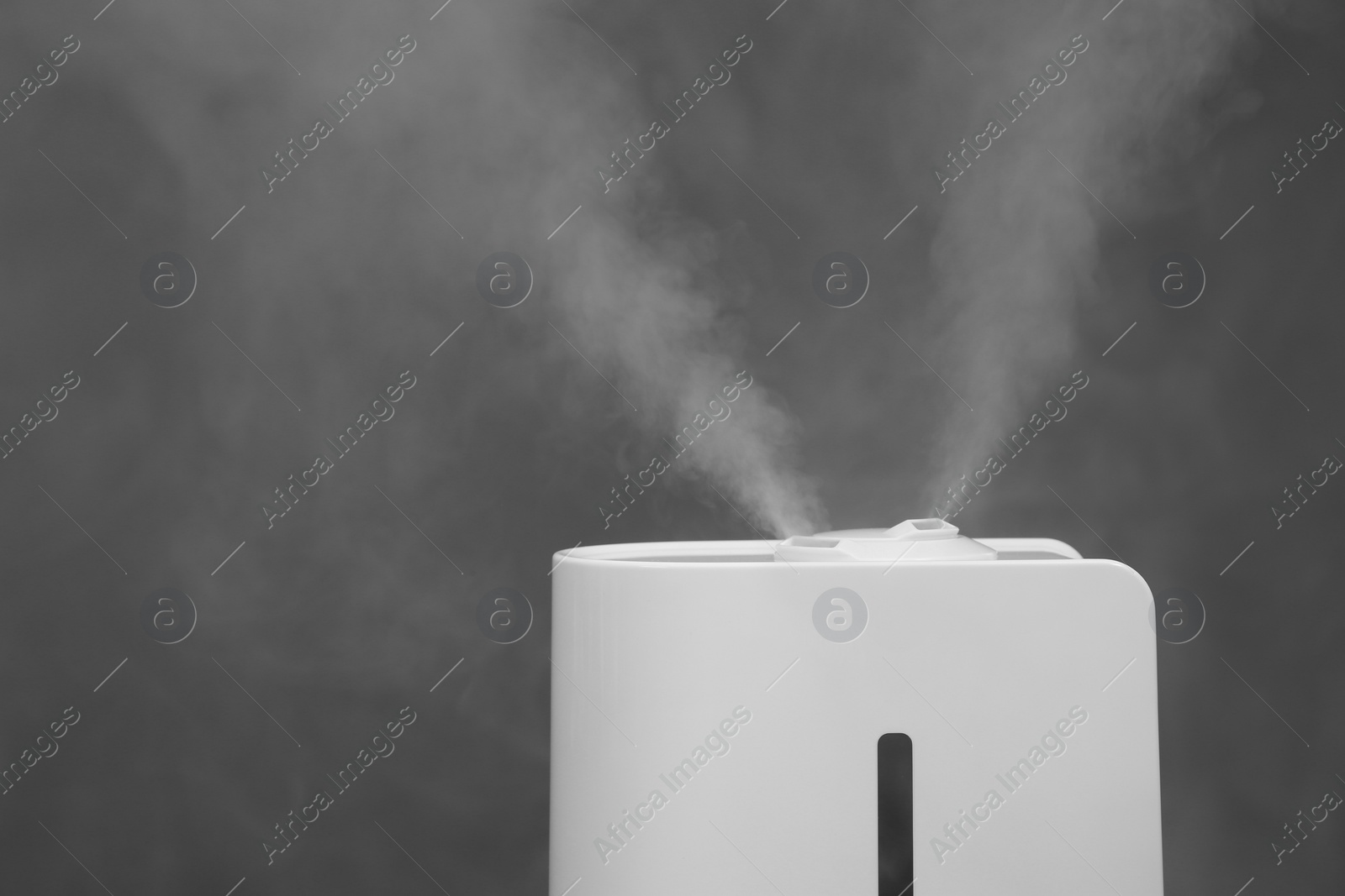 Photo of Modern air humidifier on grey background, closeup. Space for text